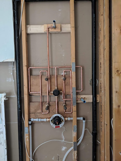 Neat copper pipe rough-in work completed by our plumbers inside wall framing